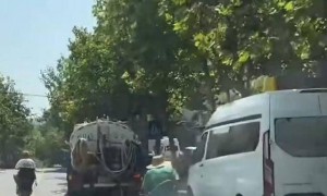 青岛一环卫工跑步追着洒水车作业引争议 官方回应:涉事司机已停职